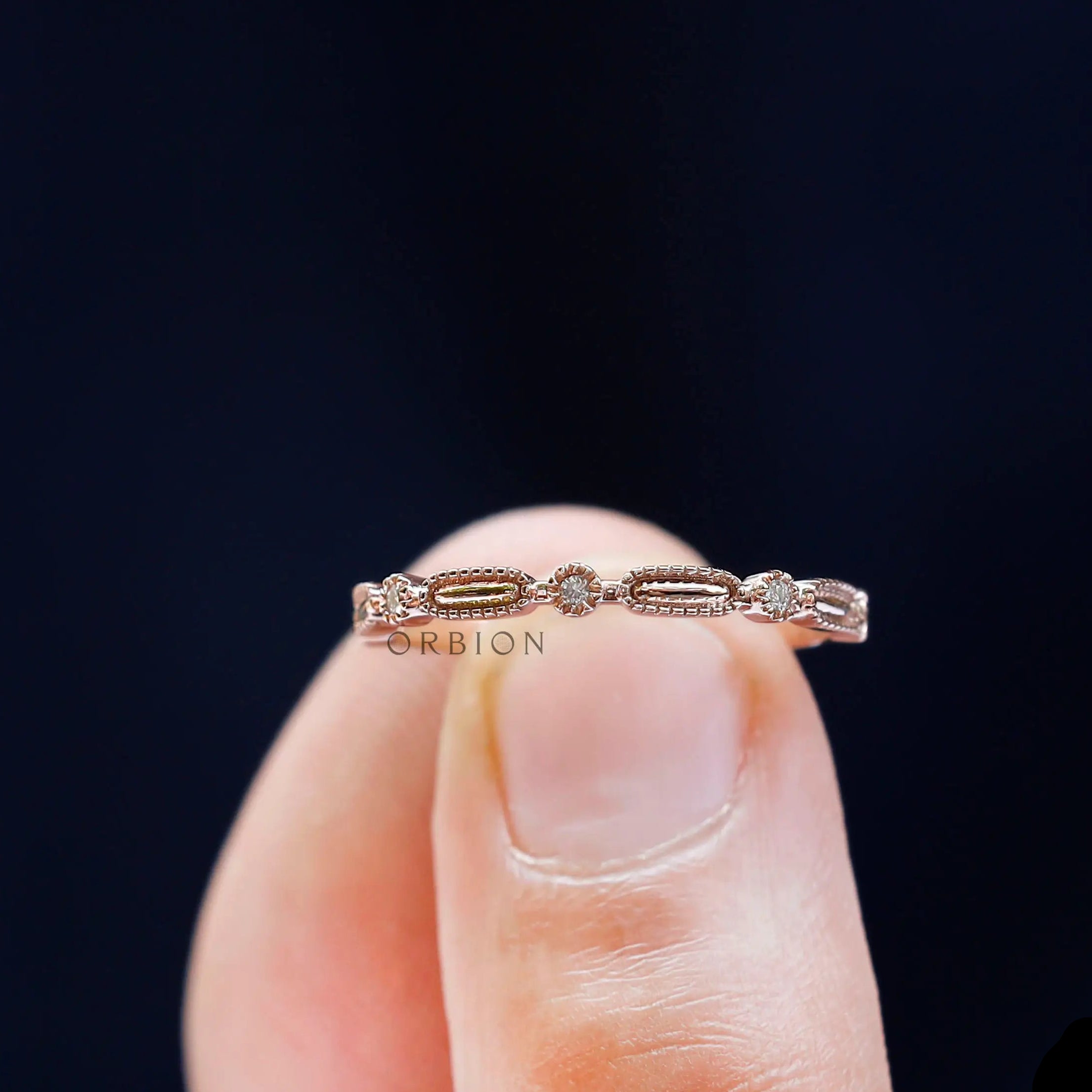 Close-up on finger geometric textured stacking band with round stones