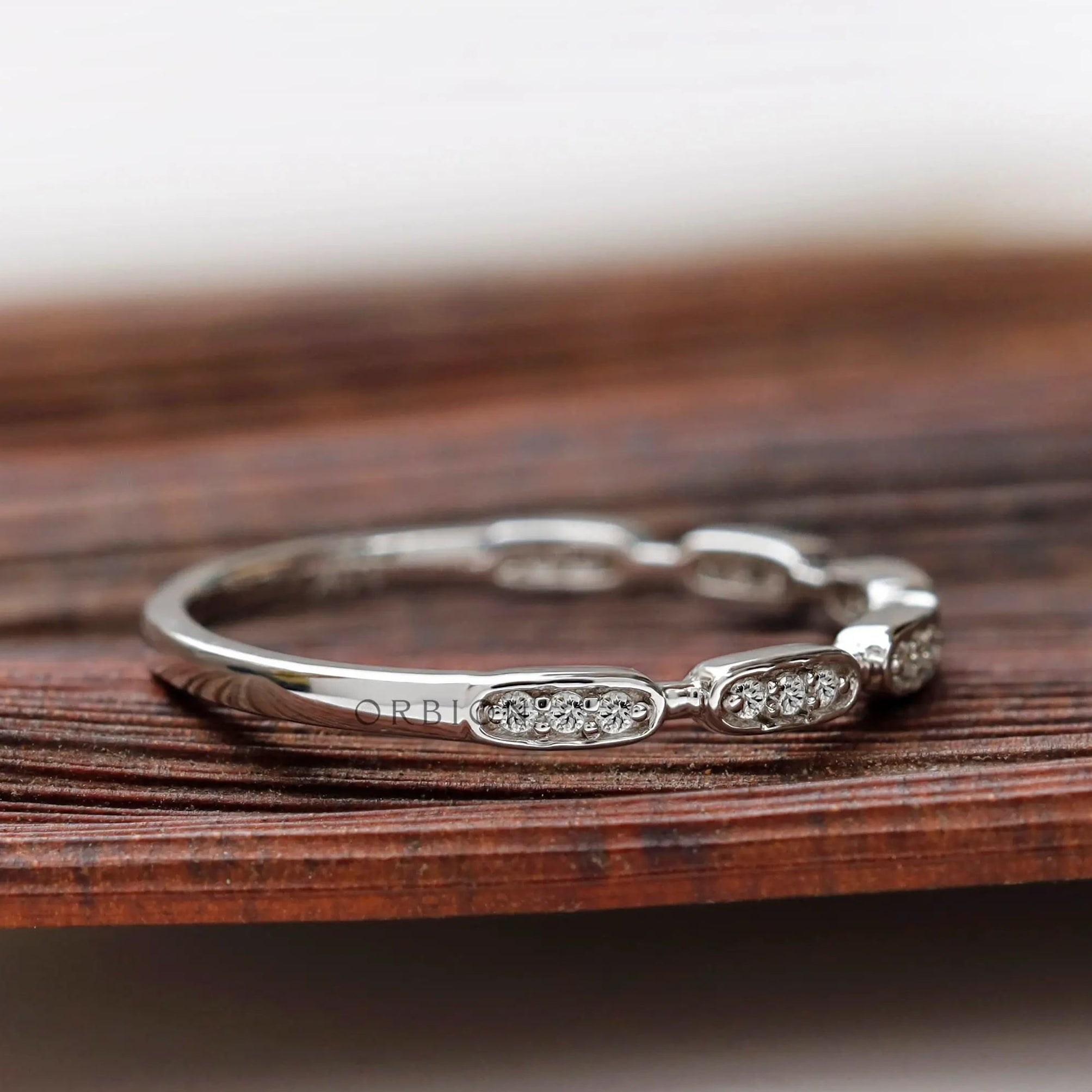 Angled view of geometric moissanite studded band