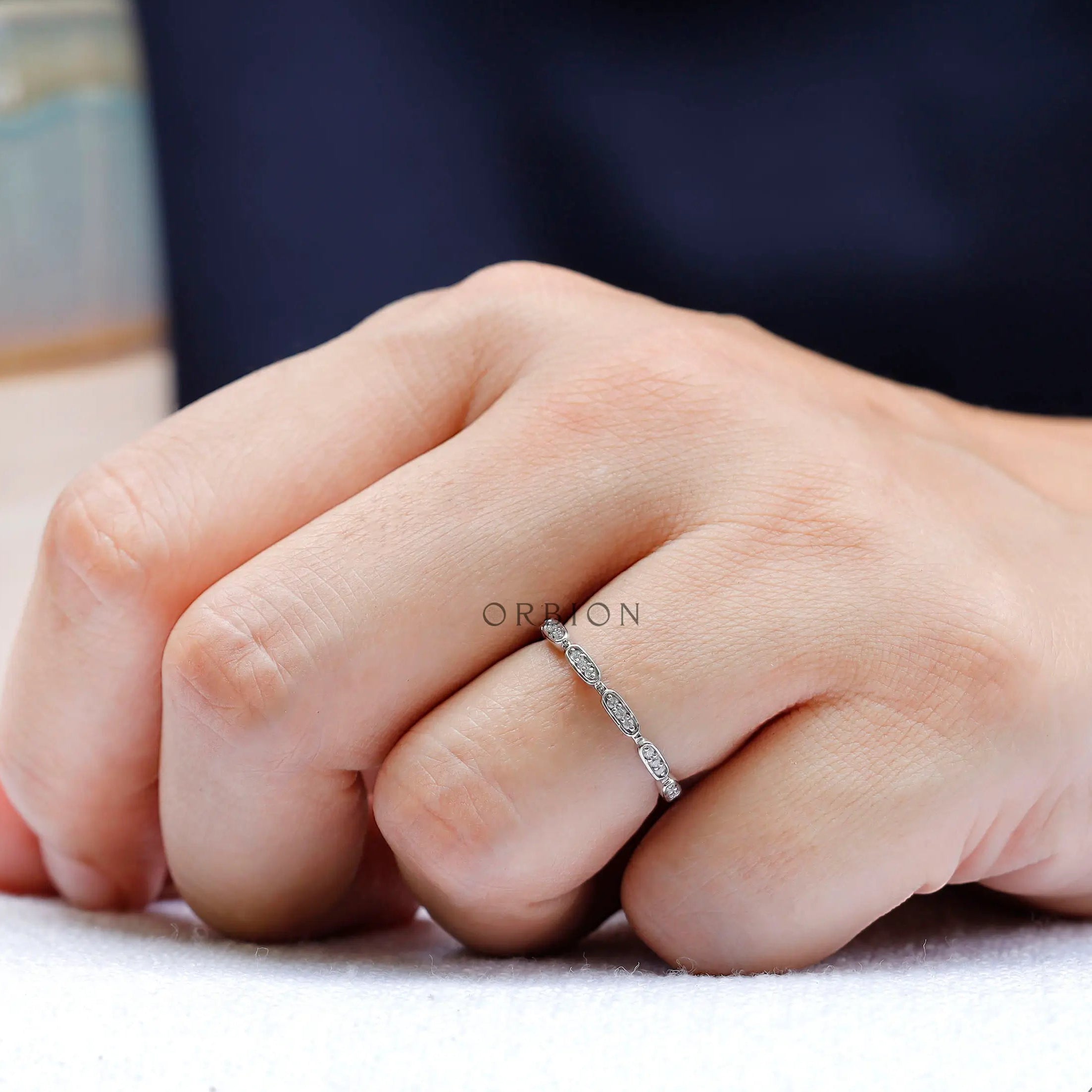 On-hand view showing slim geometric wedding band
