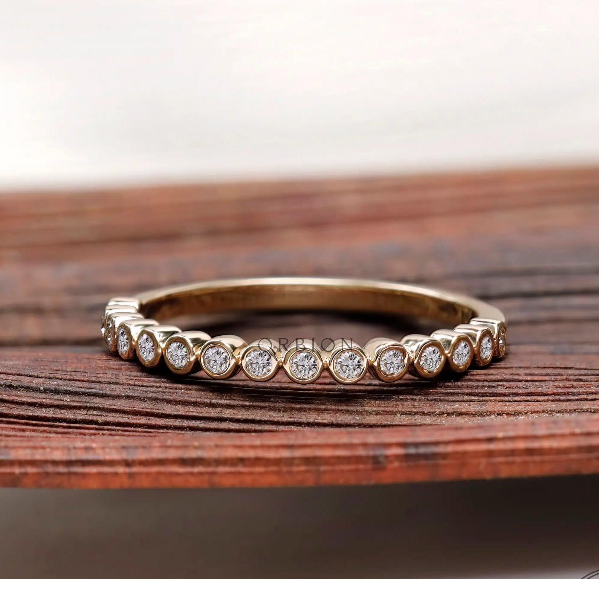 Front view of floating bubble half eternity band in yellow gold.
