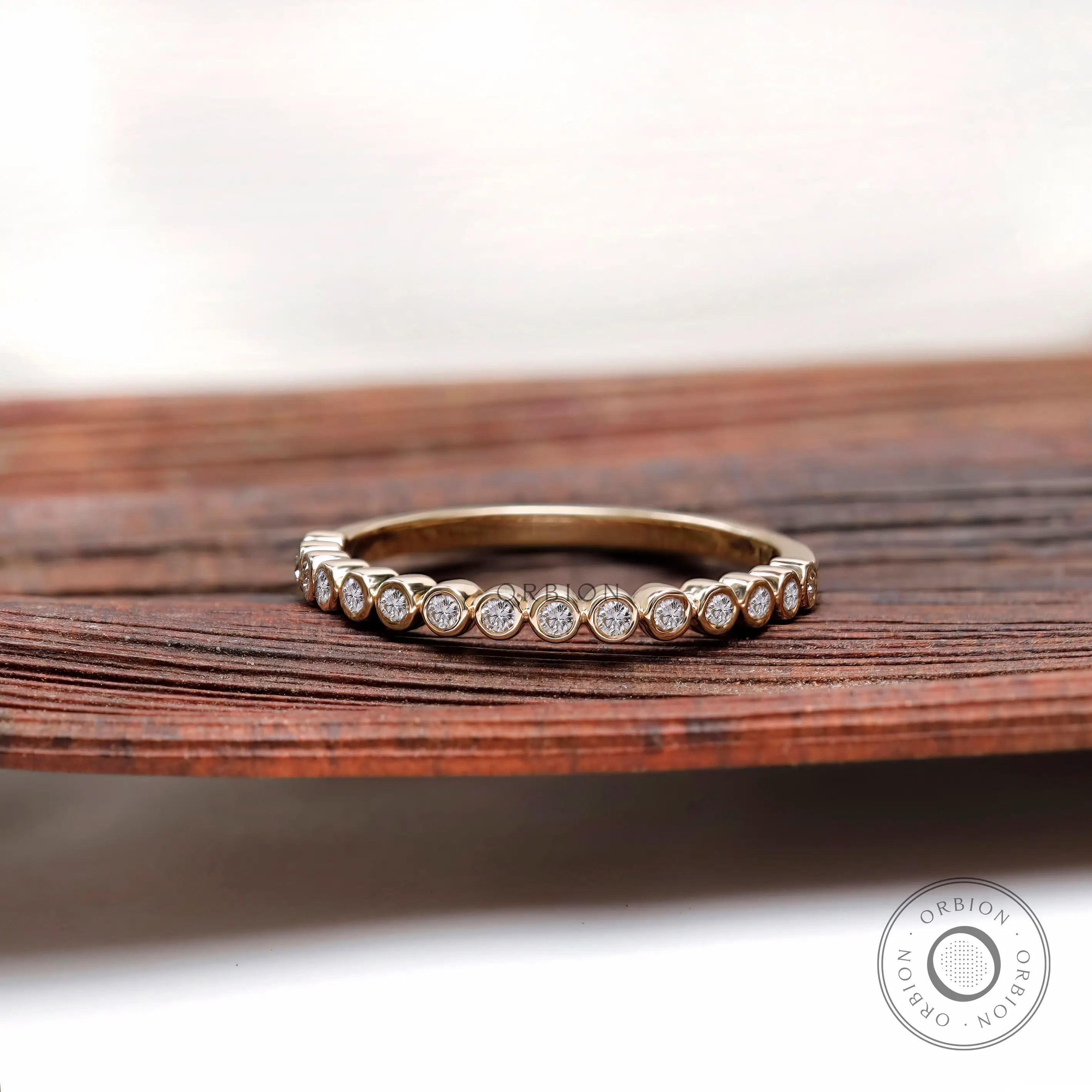 Front view of floating bubble half eternity band in yellow gold.
