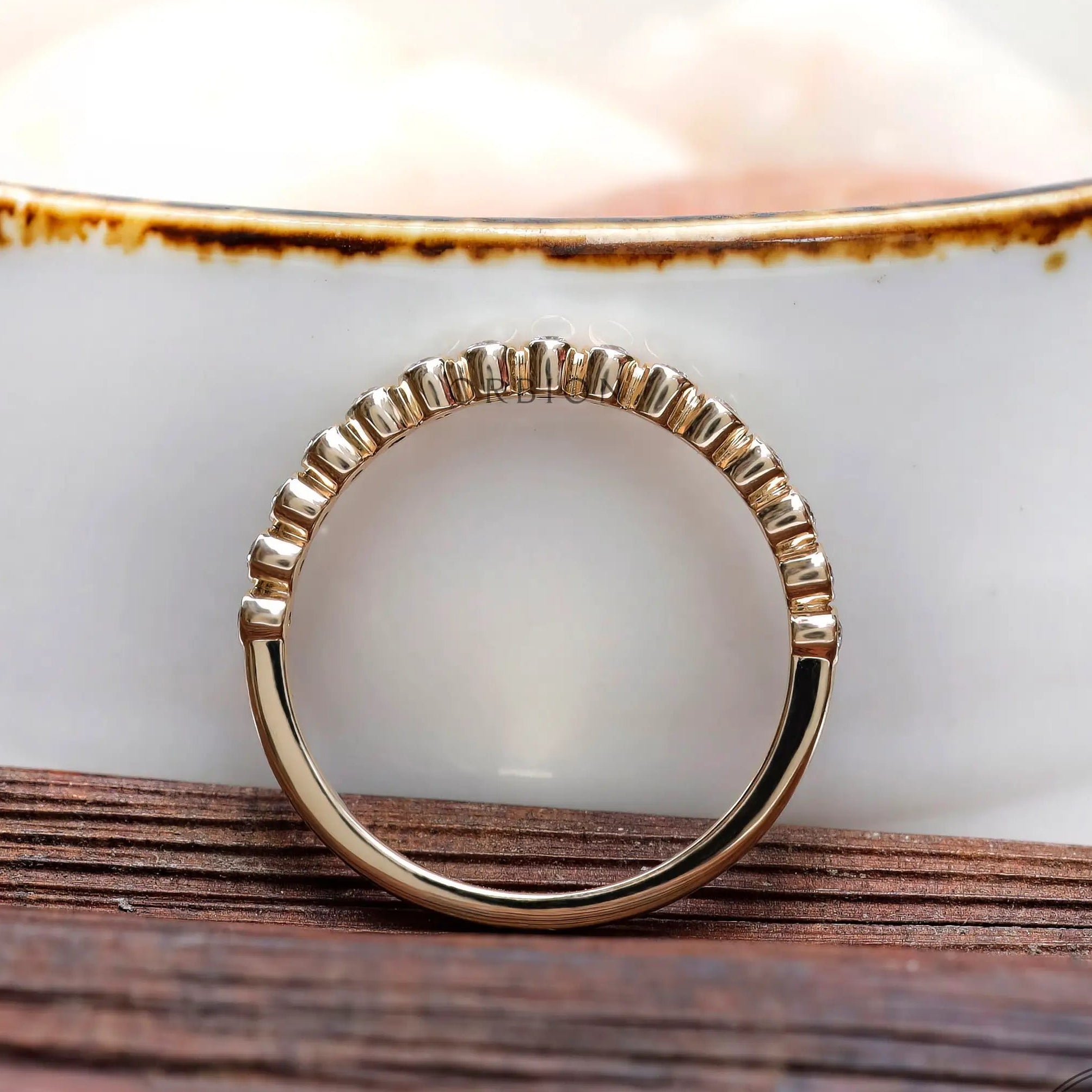 Straight profile view of floating bubble band with minimal gold shank.