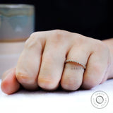 Top view on hand showing evenly spaced bezel set round moissanite.