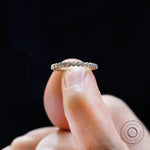 Close up of bubble half eternity band held between fingers.