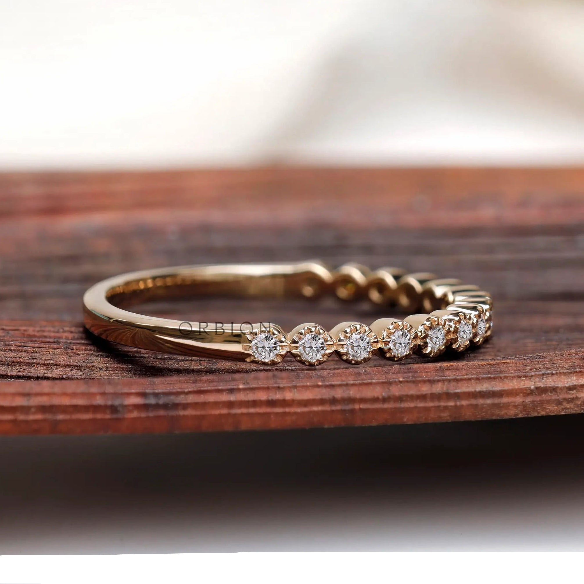 Angled side view of Art Deco bezel moissanite stacking wedding band in gold
