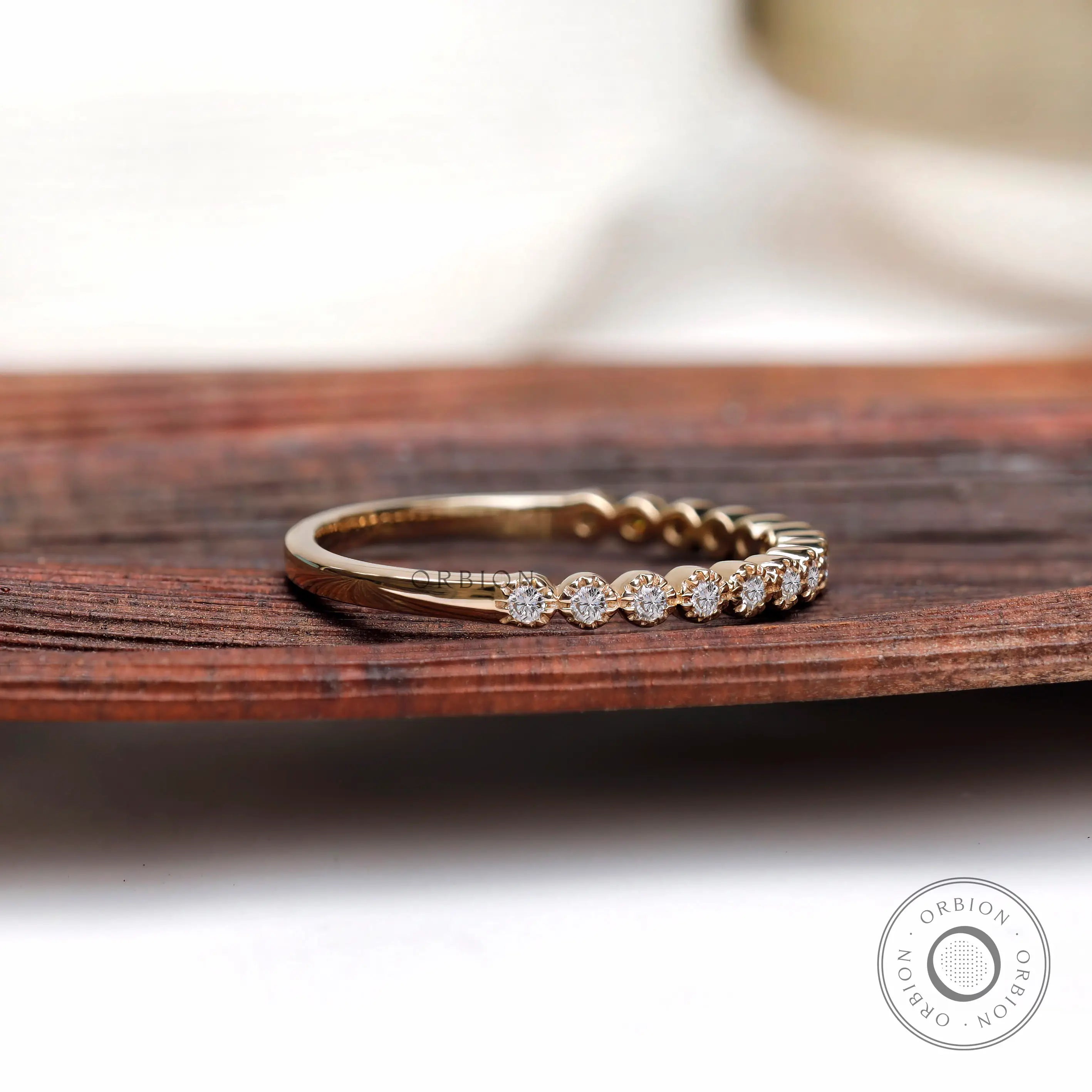 Angled side view of Art Deco bezel moissanite stacking wedding band in gold