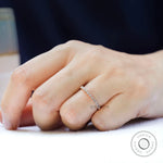 Art Deco bezel moissanite wedding band worn on finger close-up