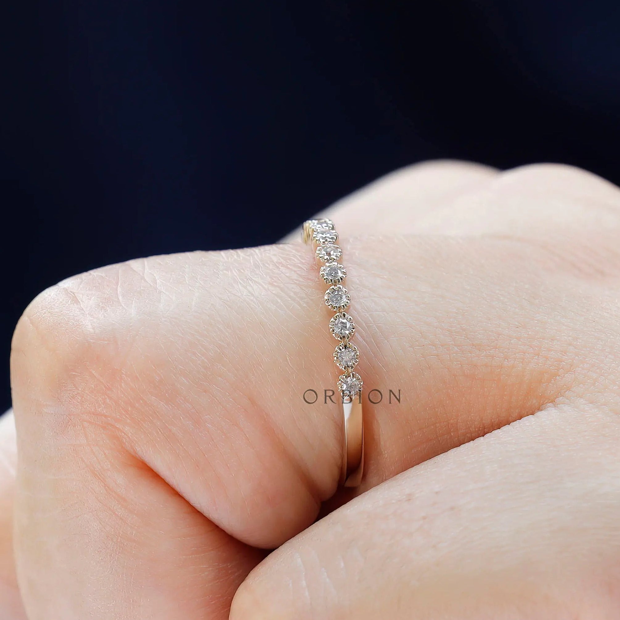 Side profile of slim bezel moissanite half eternity wedding band