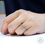Slim shared prong moissanite eternity band worn solo on finger