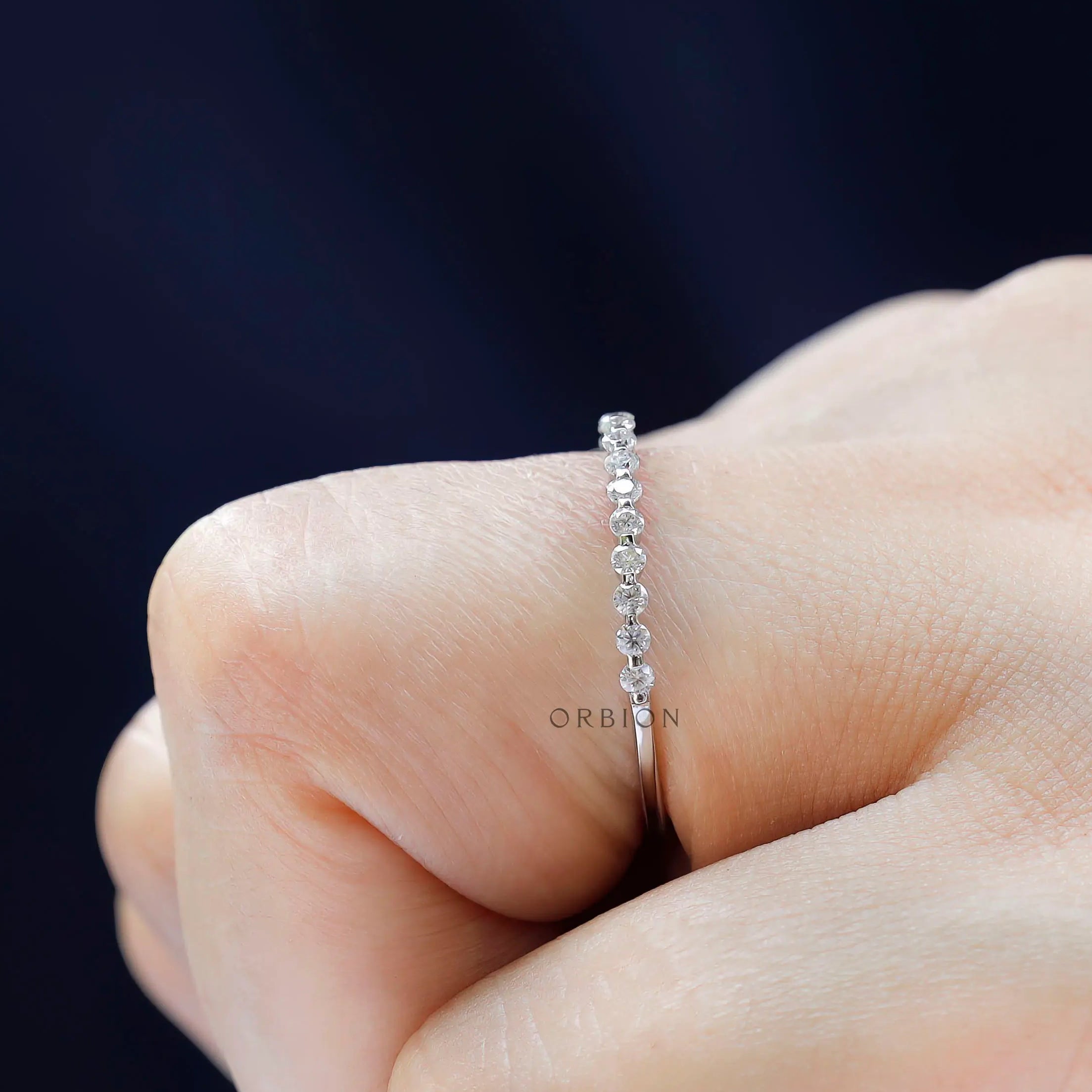 Side profile of bubble floating moissanite eternity wedding band on hand