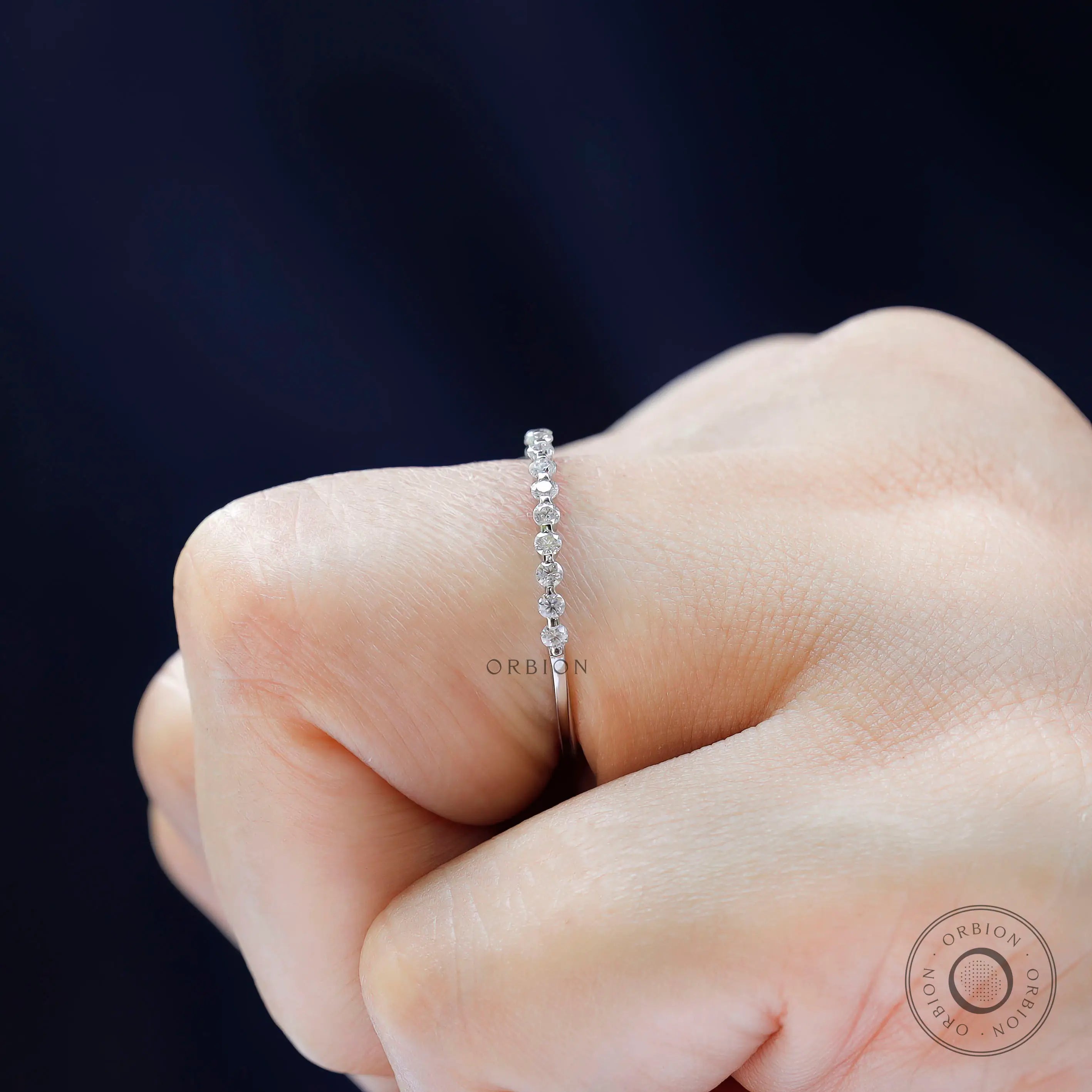 Side profile of bubble floating moissanite eternity wedding band on hand