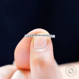 Close-up view of round cut moissanite stones in shared prong eternity band