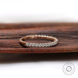 Side angle of slim U-prong eternity wedding band on wooden surface