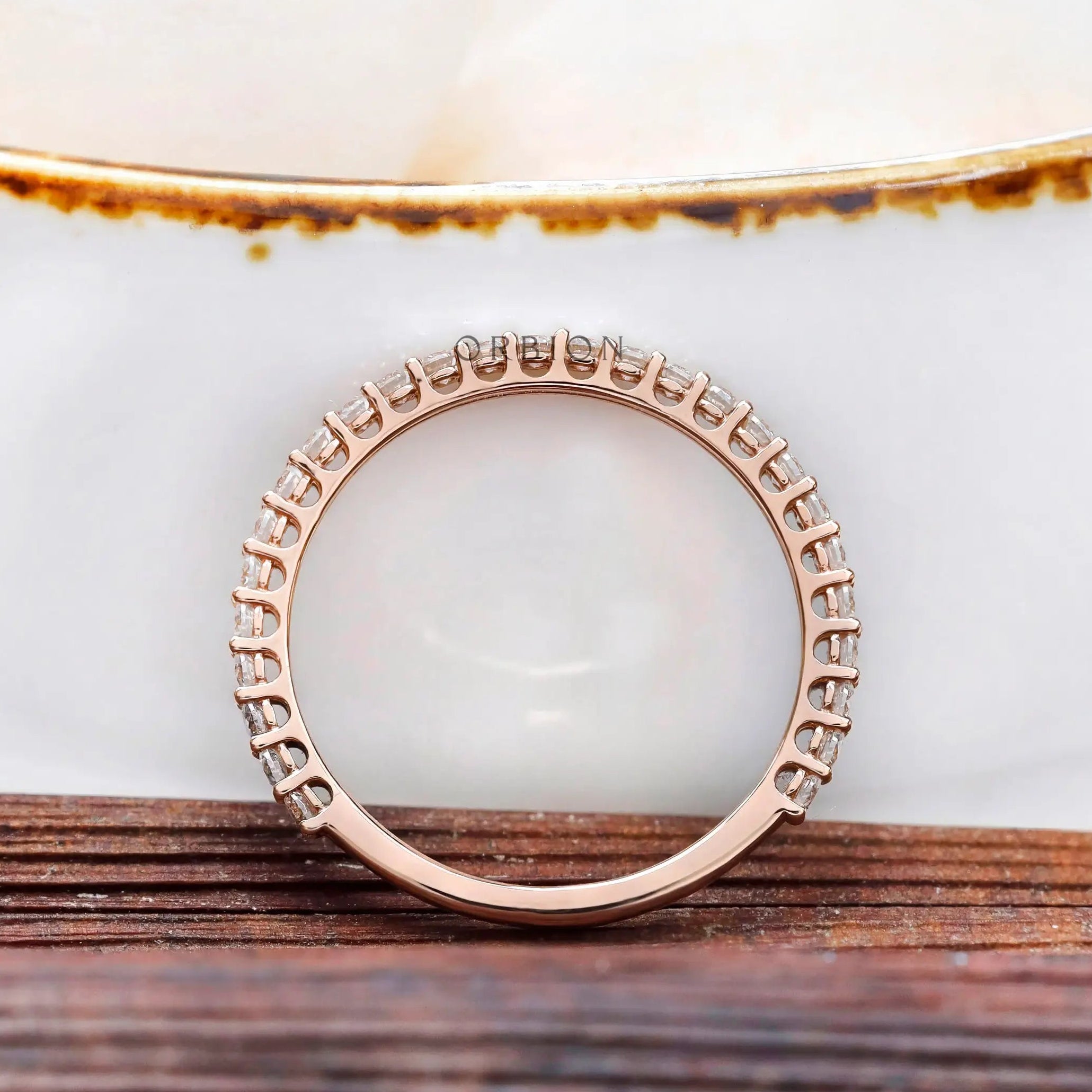 Profile view of U-prong setting and gallery on eternity band in rose gold