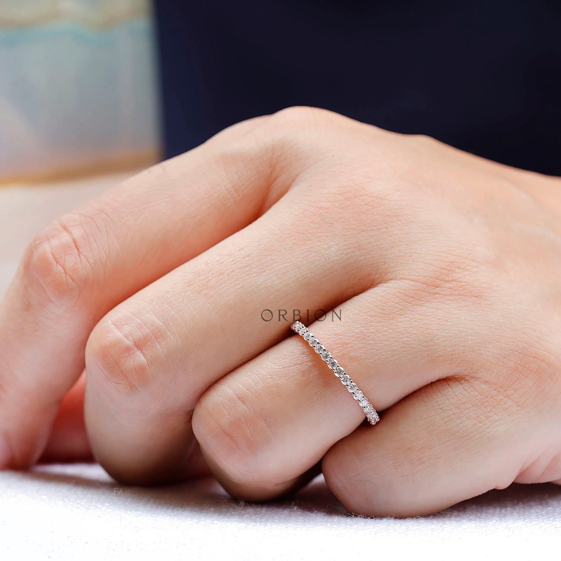 Delicate round eternity band worn on hand for stacking and matching look
