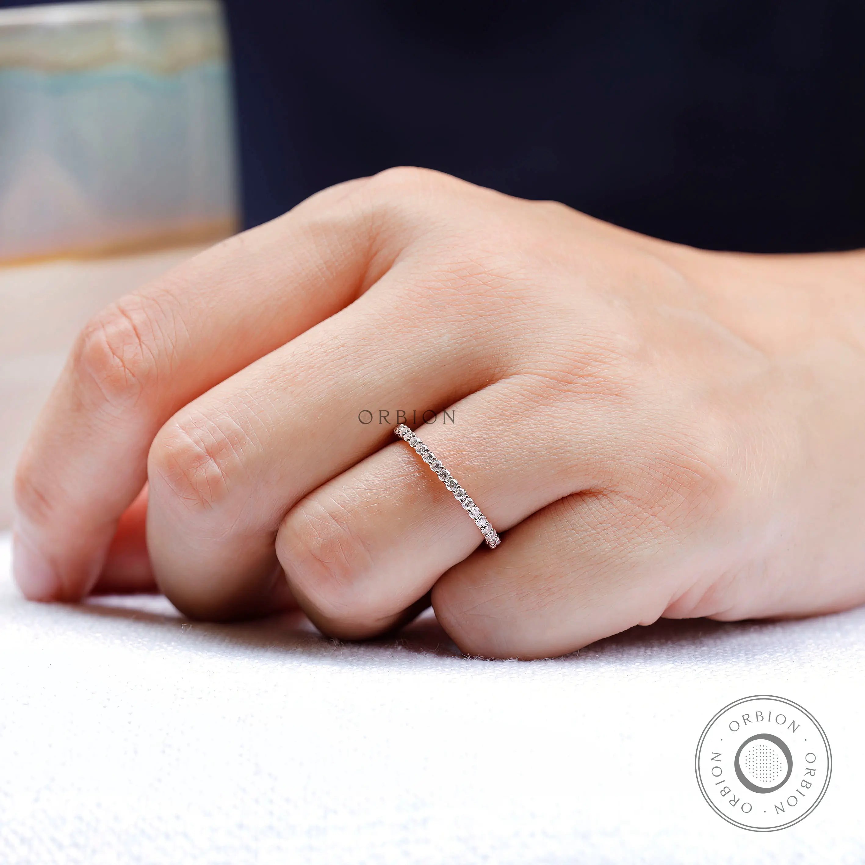 Delicate round eternity band worn on hand for stacking and matching look