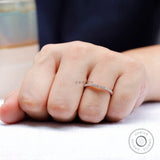 Slim U-prong wedding band in rose gold worn on hand showing low profile fit