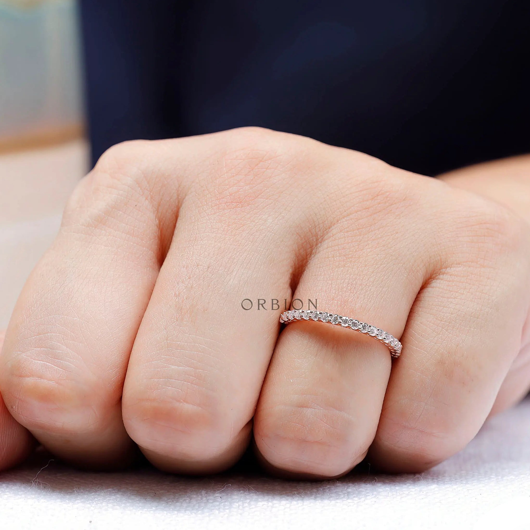 Slim U-prong wedding band in rose gold worn on hand showing low profile fit