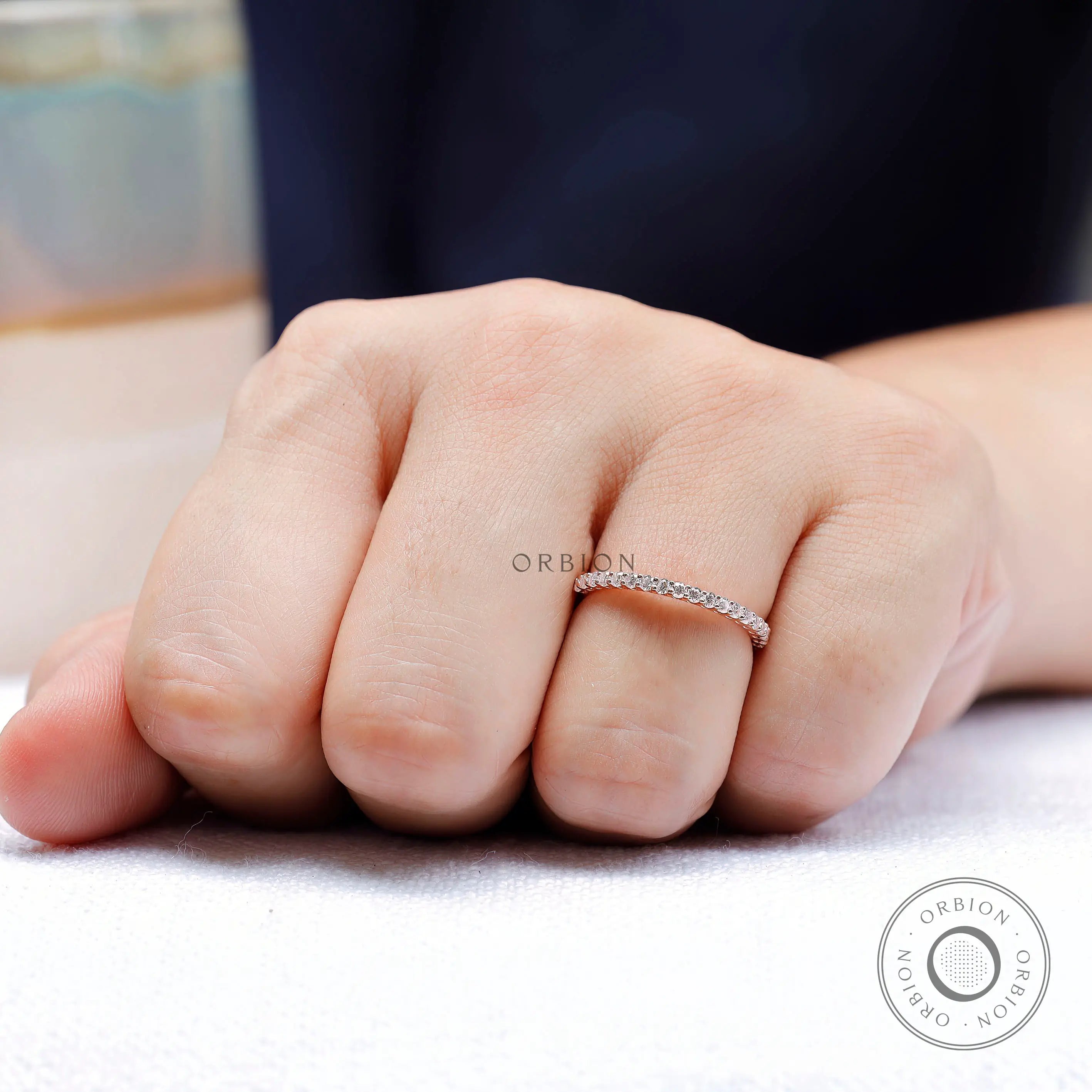 Slim U-prong wedding band in rose gold worn on hand showing low profile fit