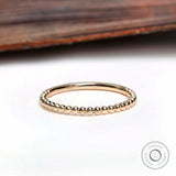 Top view of thin beaded gold band showing delicate ball detailing
