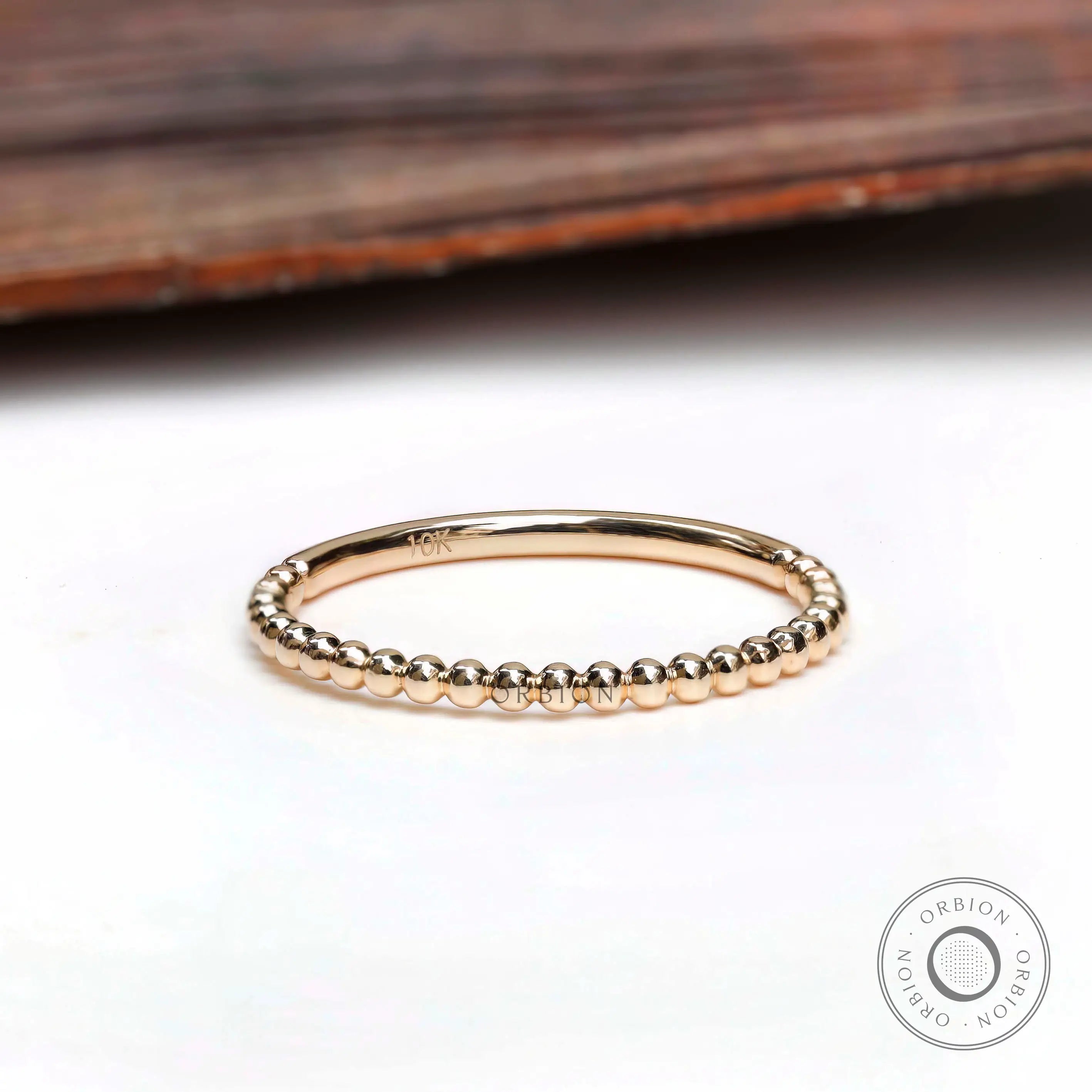 Top view of thin beaded gold band showing delicate ball detailing