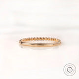 Back view of dainty beaded gold band with plain polished shank