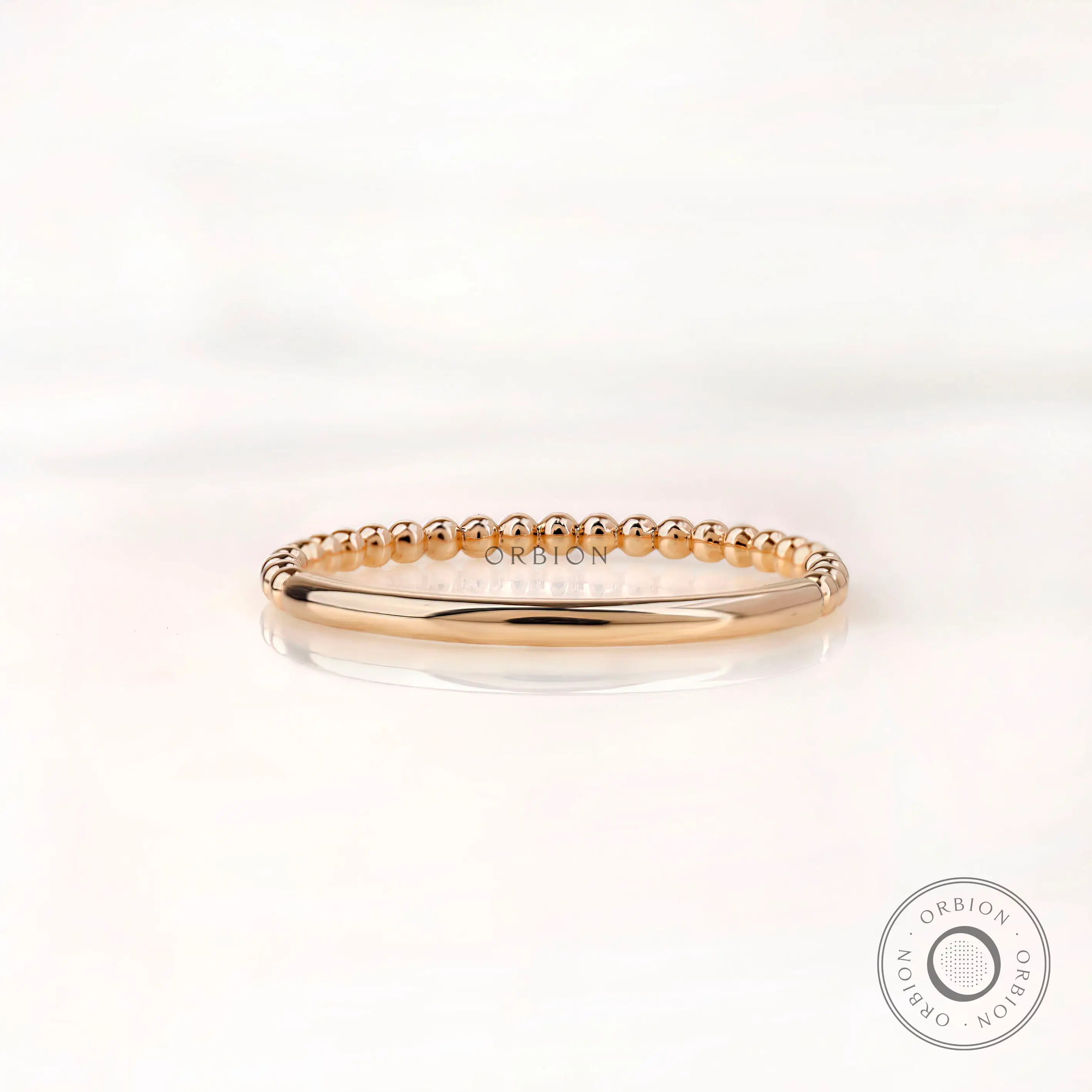 Back view of dainty beaded gold band with plain polished shank