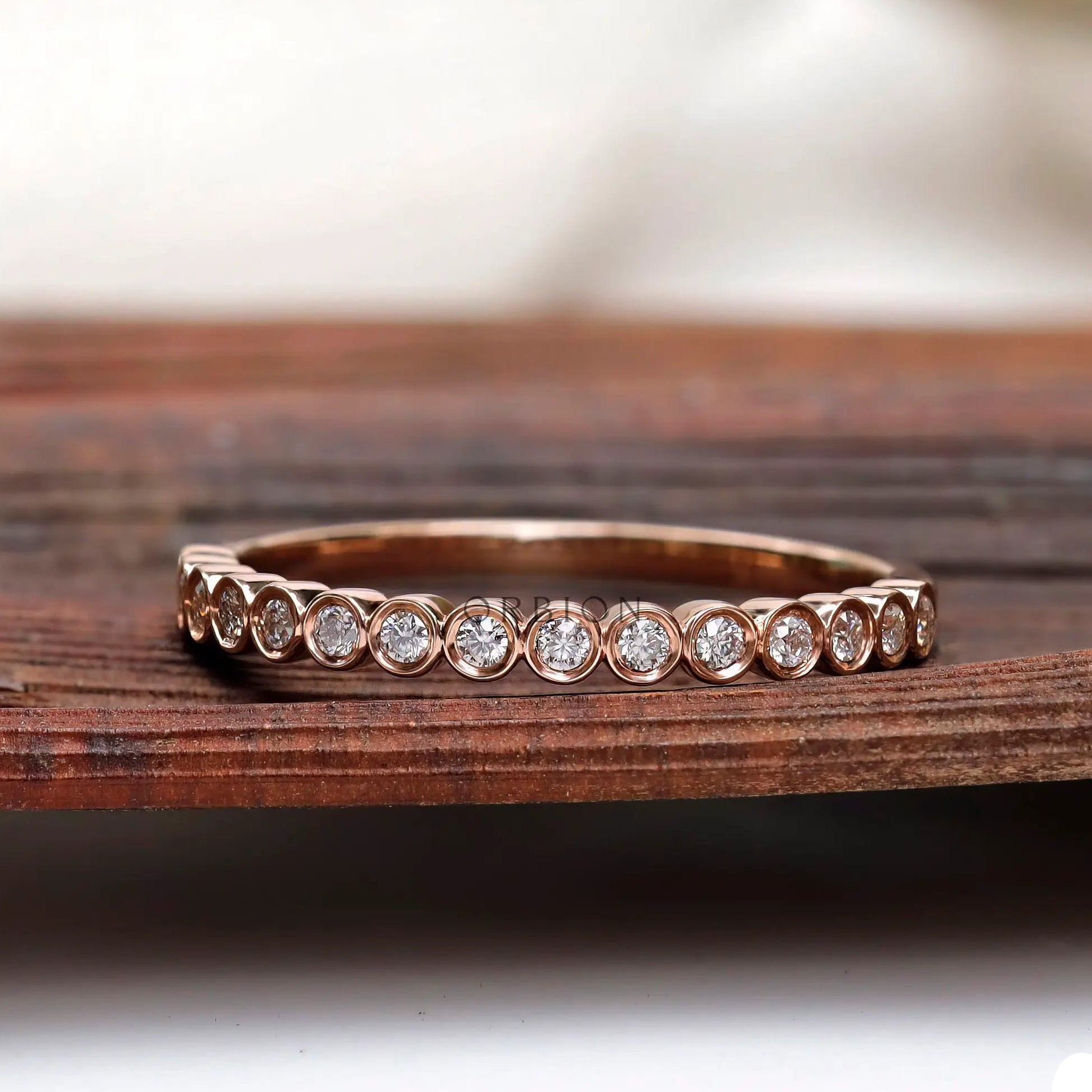 Bezel set round moissanite half eternity band front view
