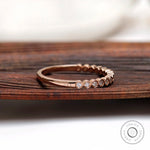 Side angle view of bezel set moissanite half eternity ring