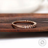 Side angle view of bezel set moissanite half eternity ring