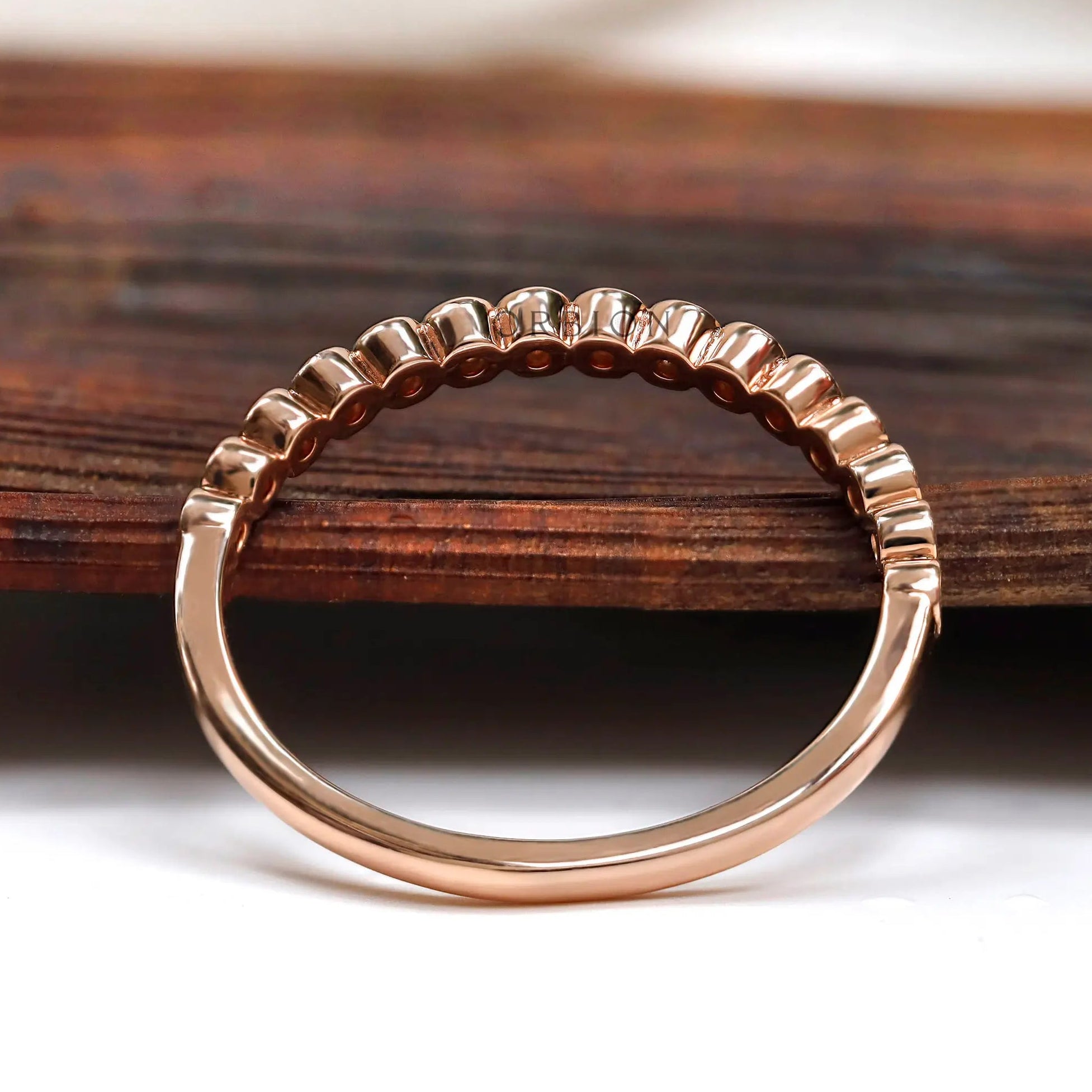 Profile view showing tapered band with bezel set stones