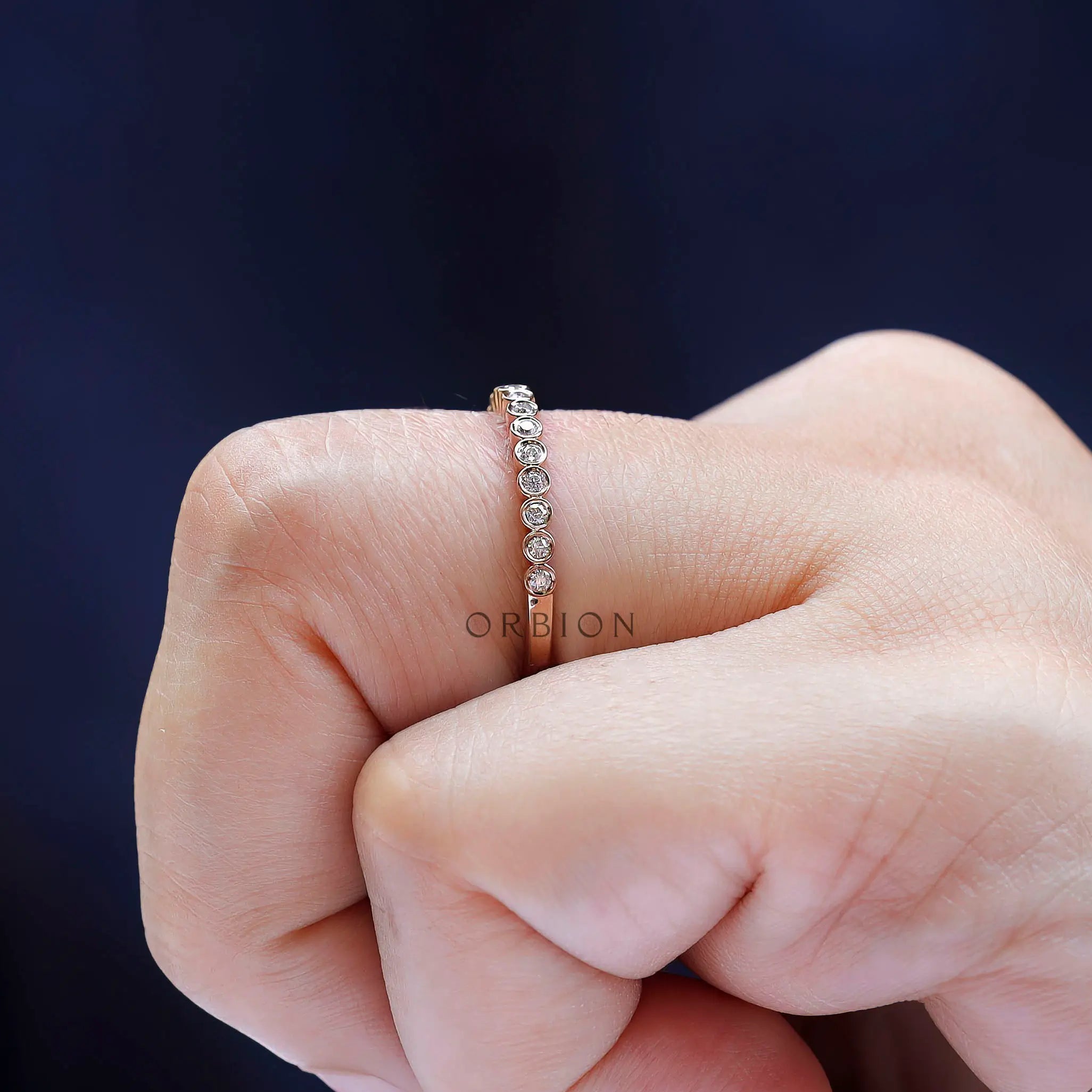 Lifestyle view of delicate rose gold moissanite half eternity ring