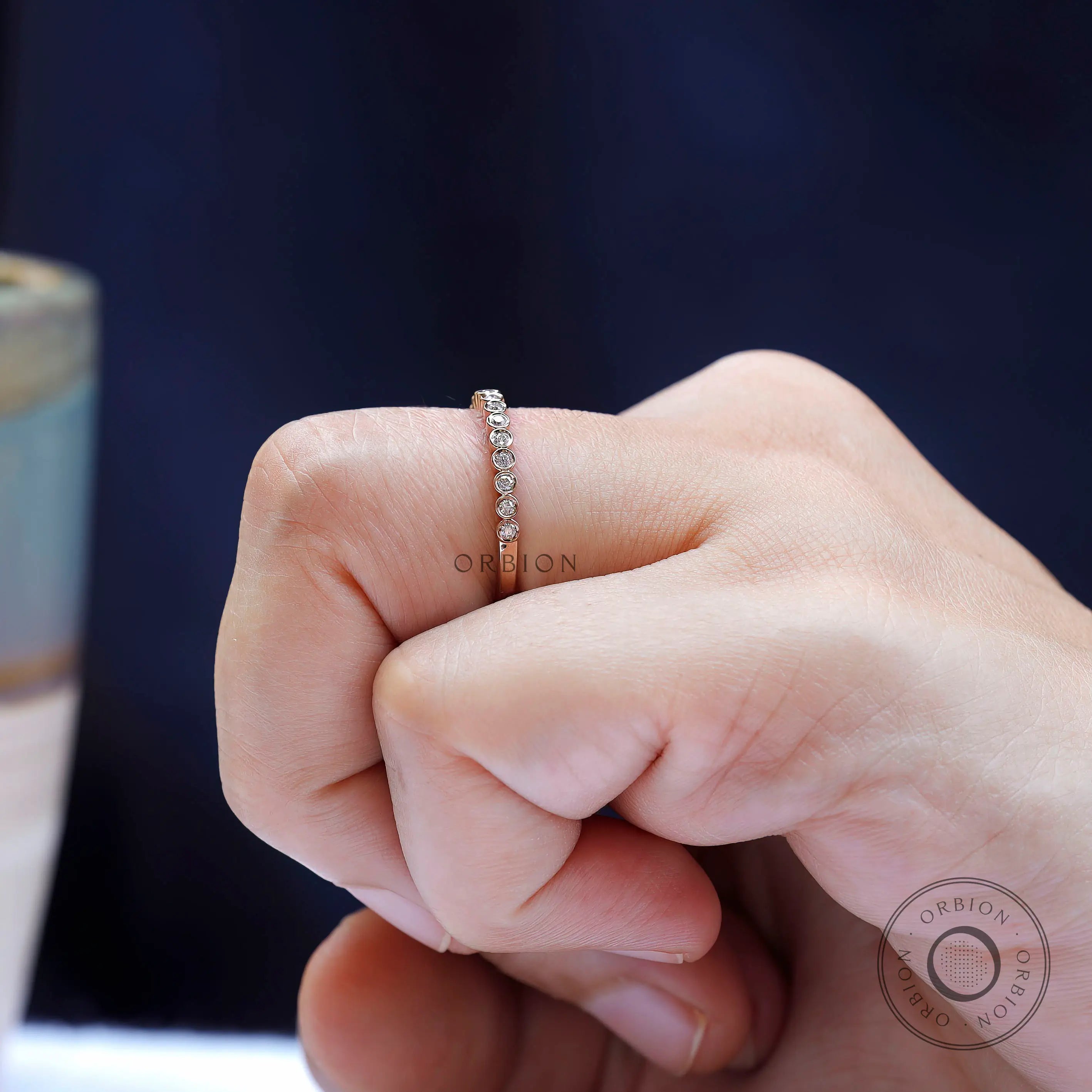 Lifestyle view of delicate rose gold moissanite half eternity ring