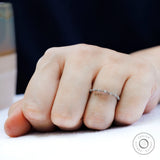 Dainty floating bubble moissanite band in white gold, angled on-hand view