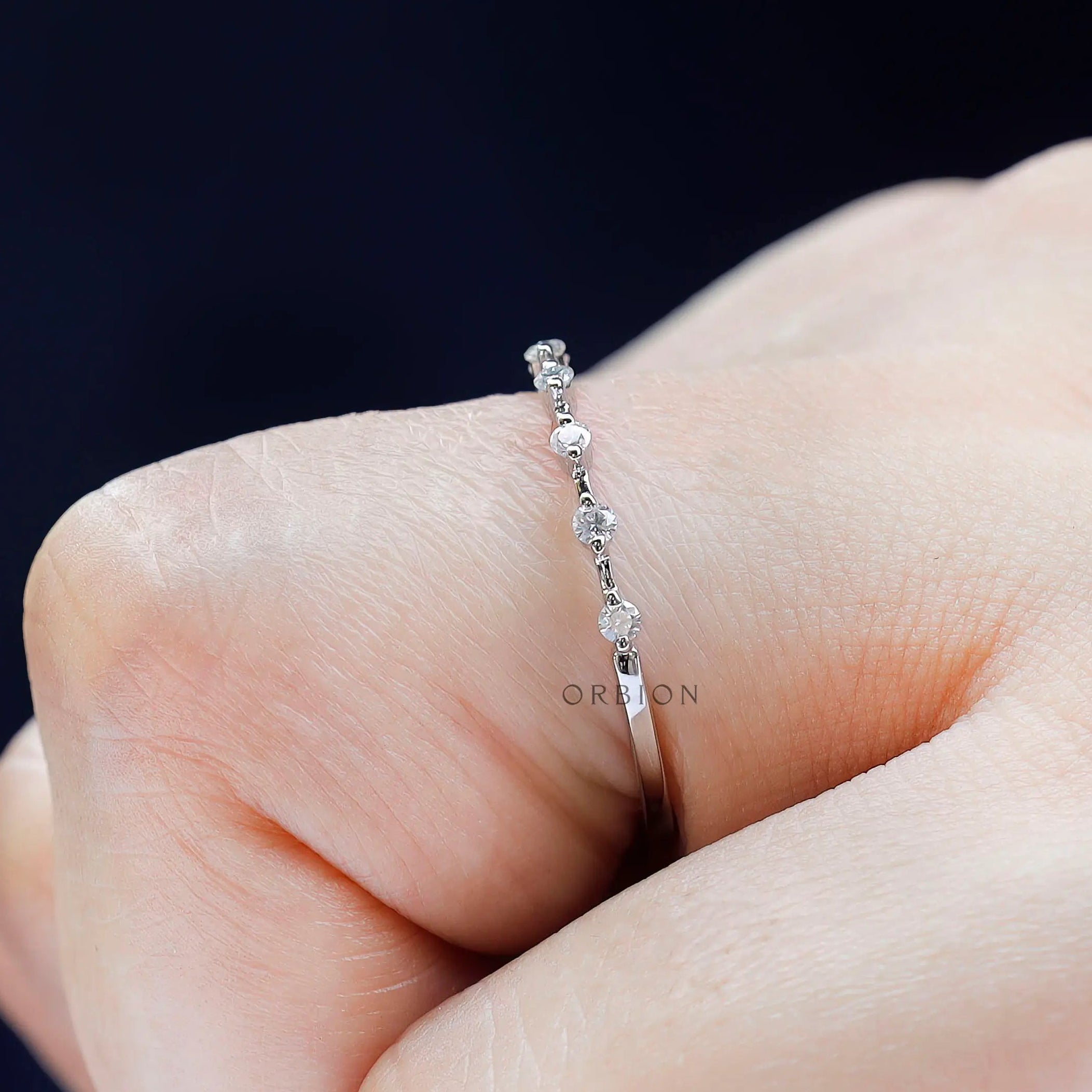 Close-up of single prong round bubble band, delicate half eternity design