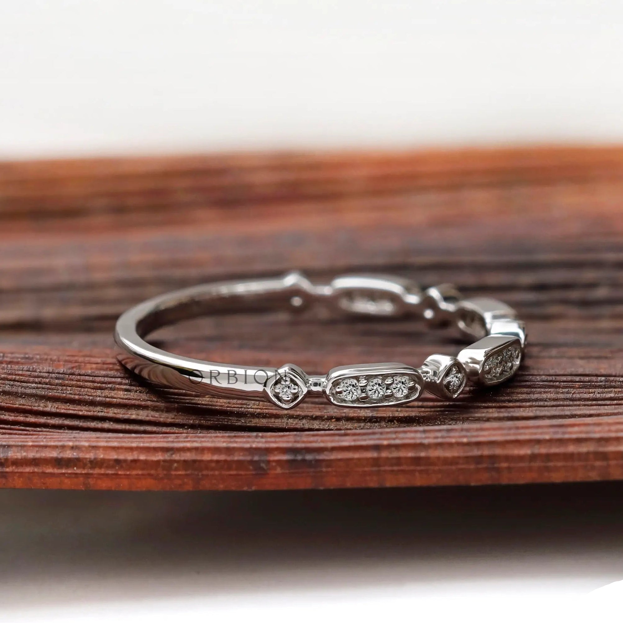 Angled side view of geometric moissanite stacking band in solid gold
