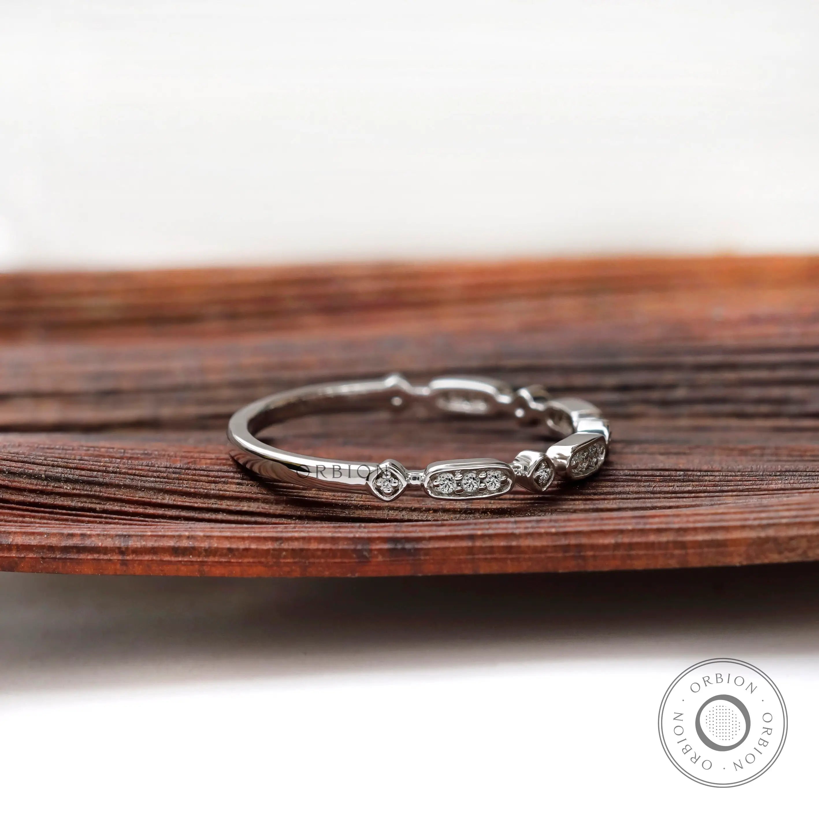 Angled side view of geometric moissanite stacking band in solid gold