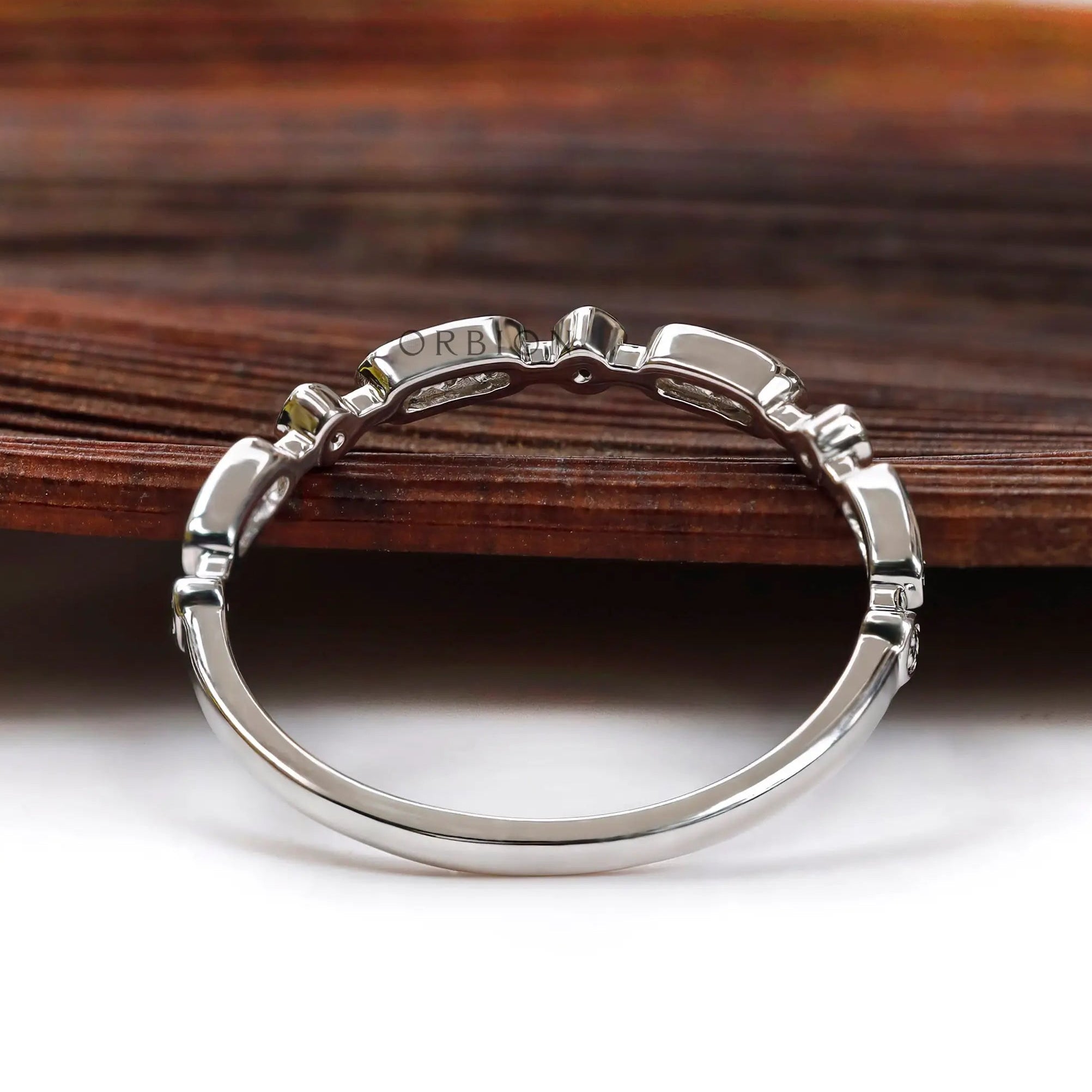 Back profile of slim geometric moissanite wedding band showing band curvature