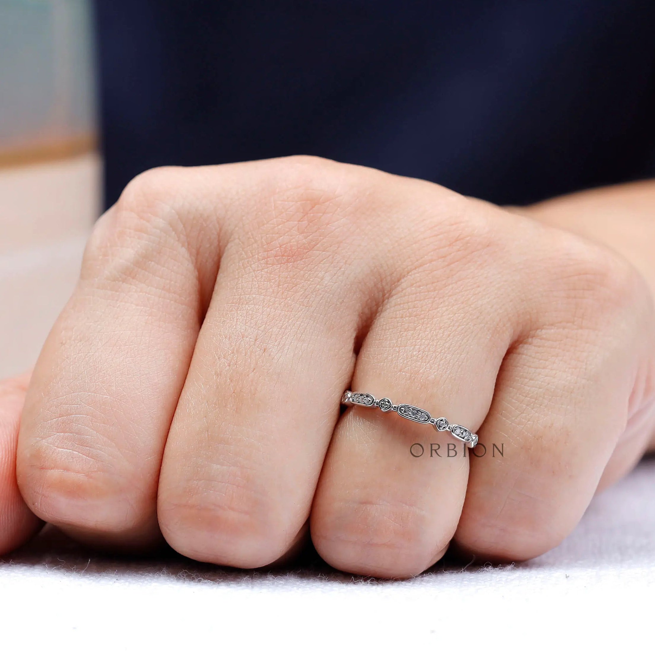 Minimal geometric moissanite stacking band worn on hand lifestyle view