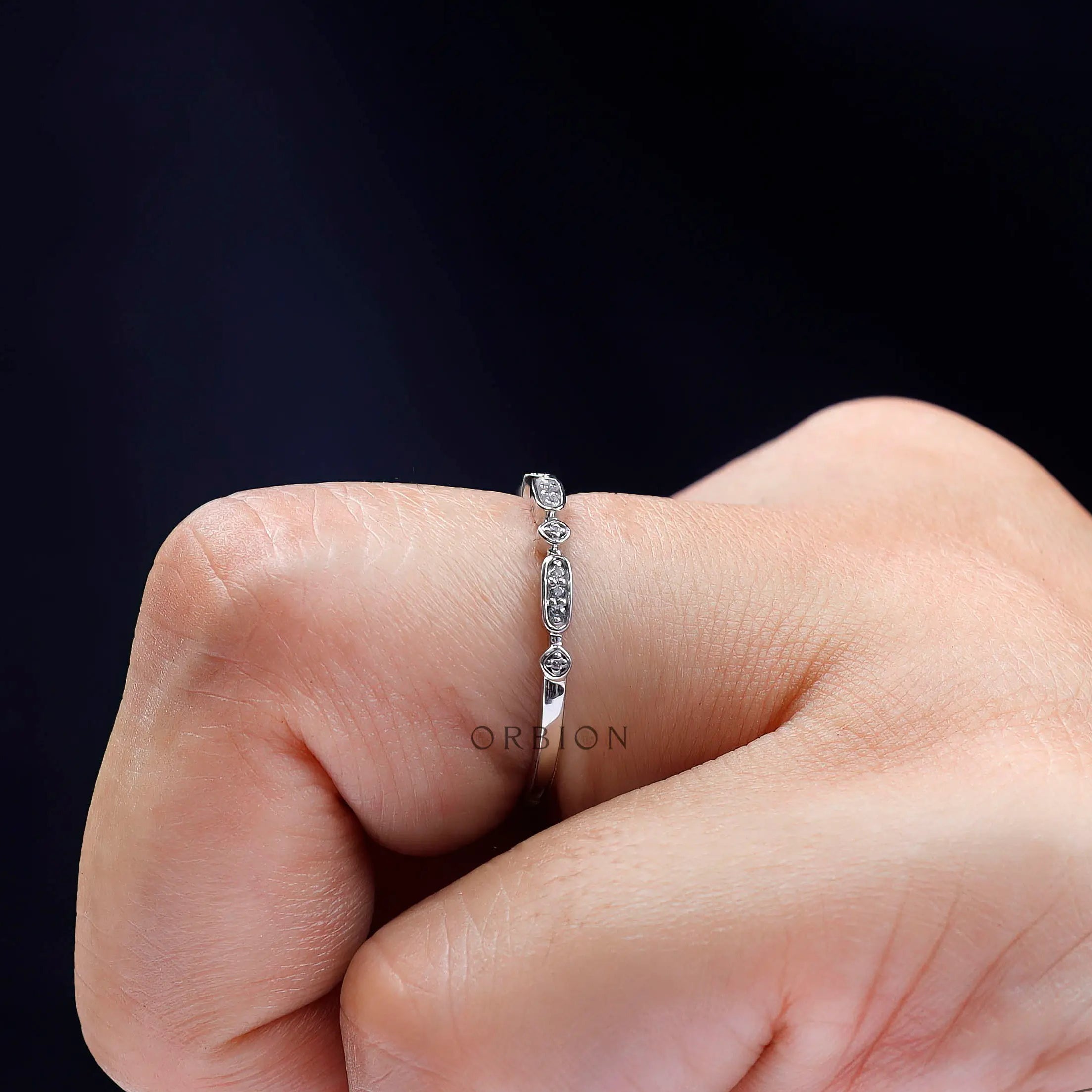 Side angle of geometric moissanite wedding band highlighting bezel details