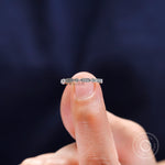 Close-up view of geometric moissanite stones arranged along slim gold band