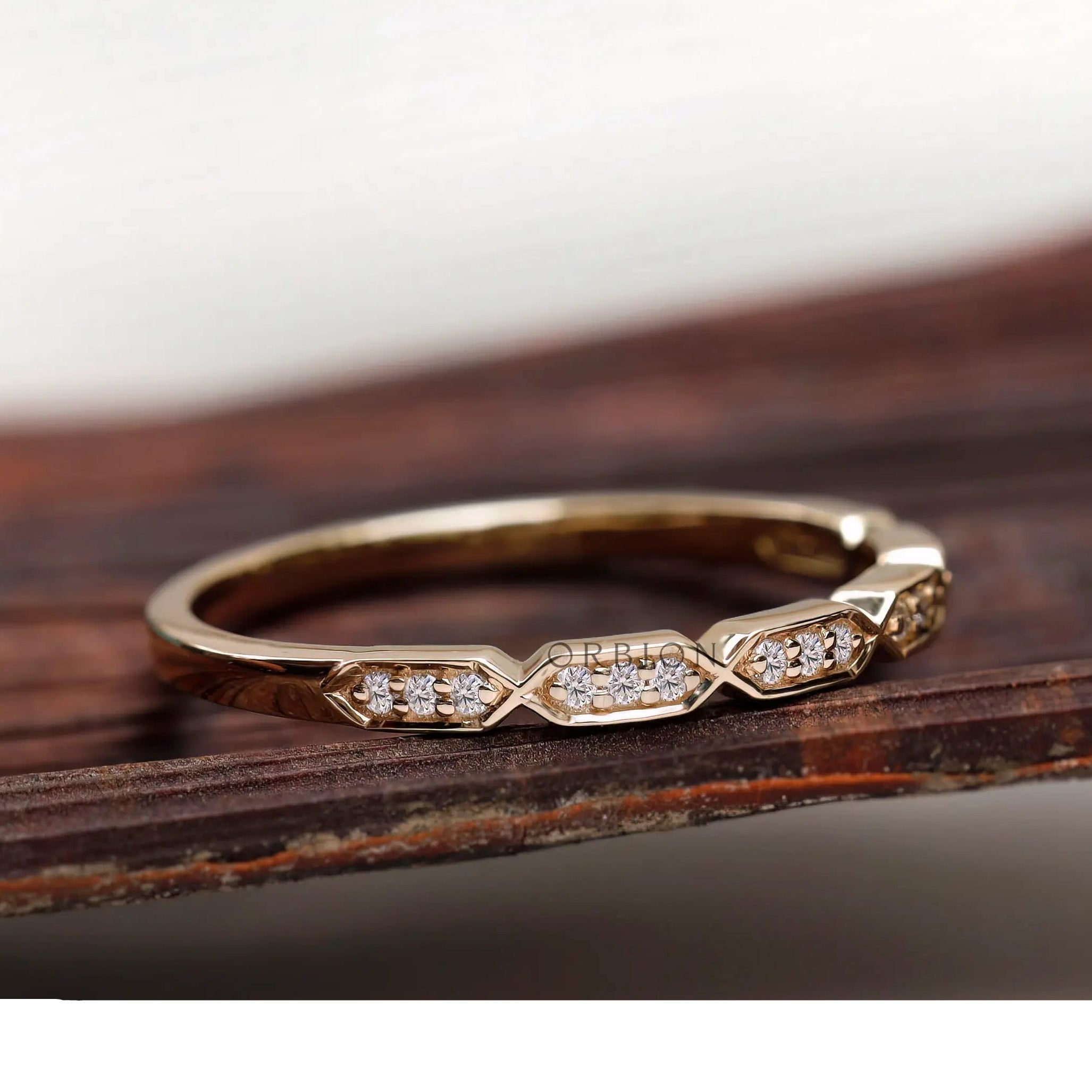 Angled view of geometric hexagon diamond stacking band in solid gold