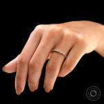 Geometric hexagon moissanite wedding band worn on finger close-up