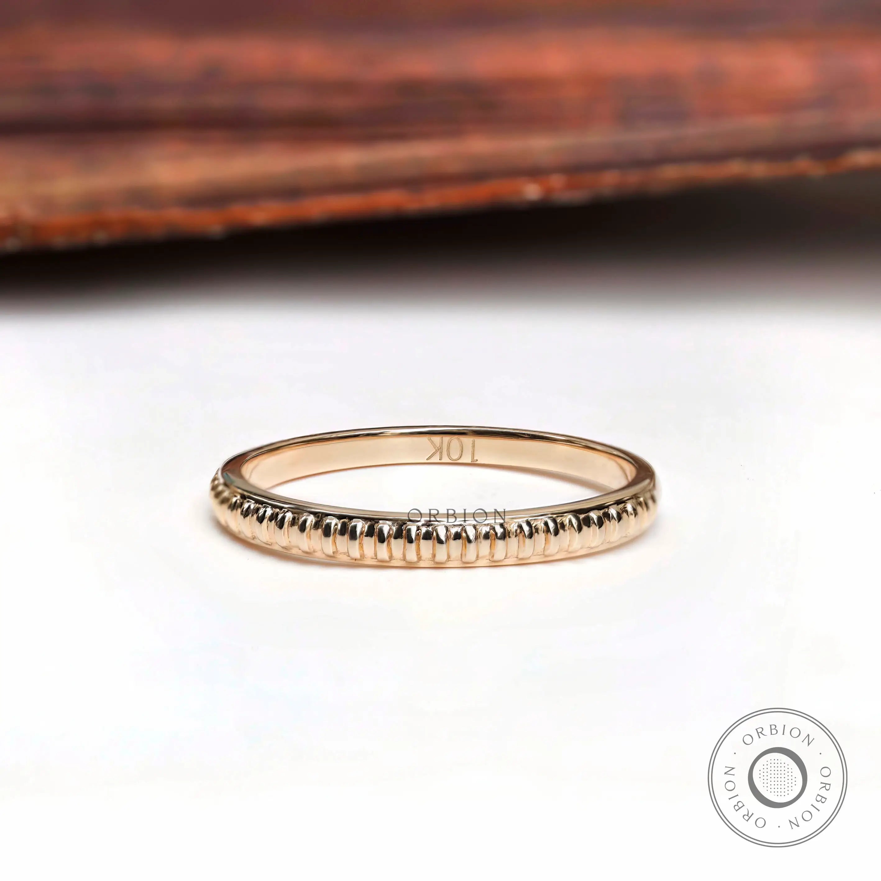 Angled view of fluted texture yellow gold minimalist wedding band