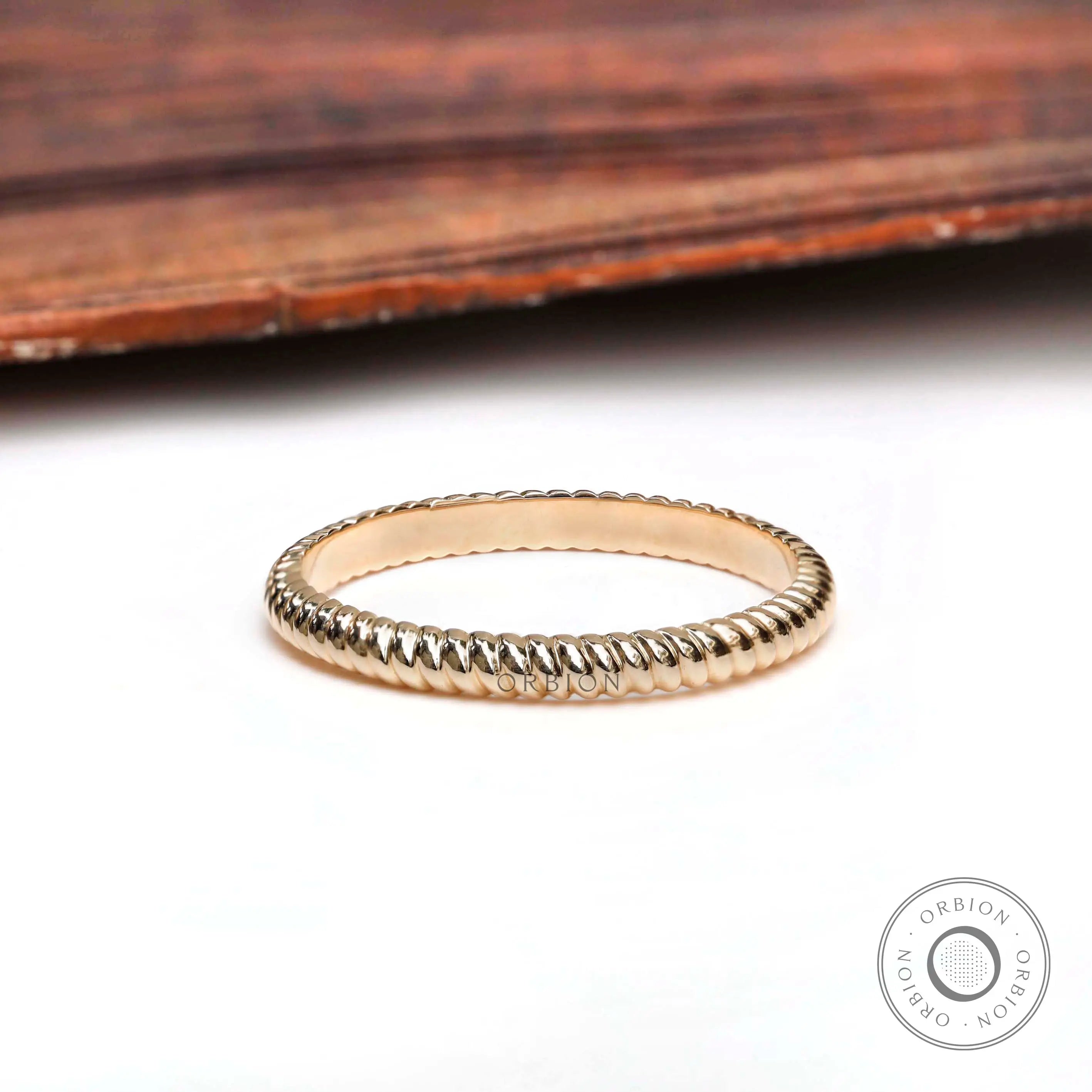 Elegant twisted rope design gold eternity band, angled view