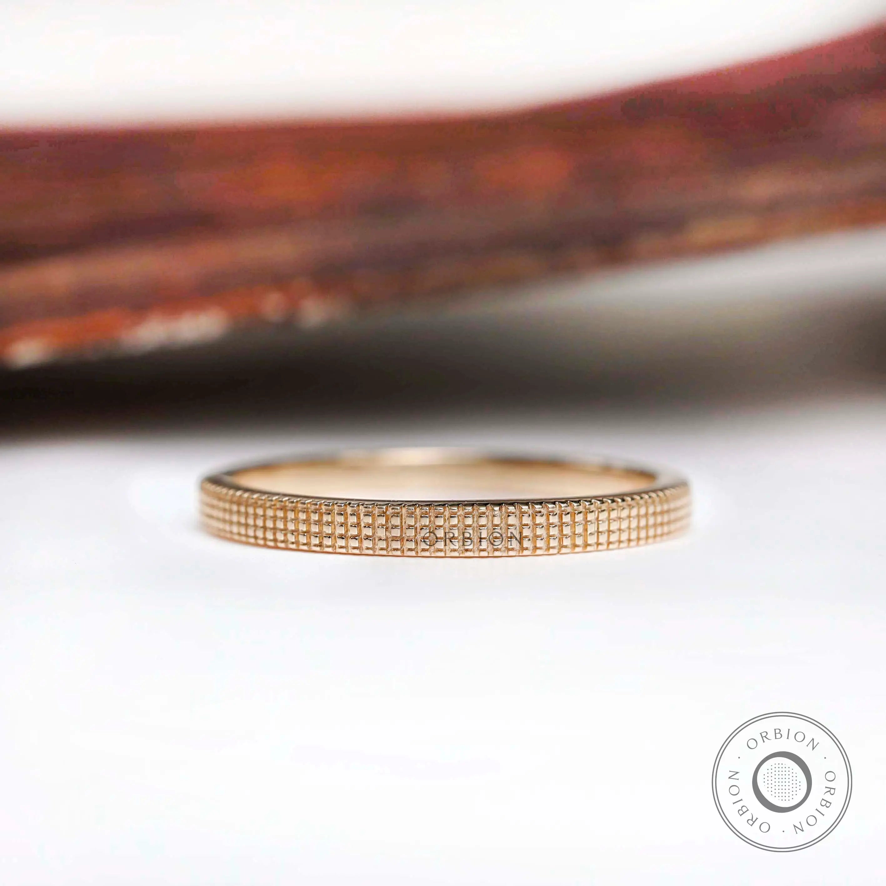 Half textured lattice thin wedding band, front view on white background
