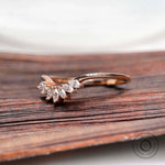 Angled view of marquise moissanite curved nesting band in rose gold