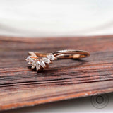 Angled view of marquise moissanite curved nesting band in rose gold