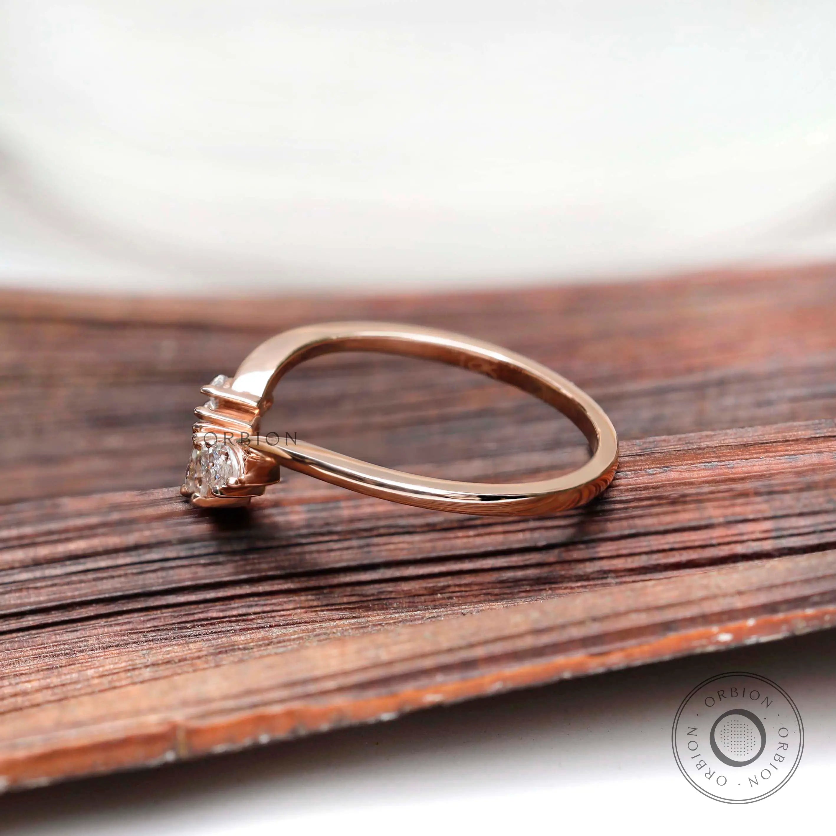 Side profile of curved marquise moissanite nesting band in rose gold