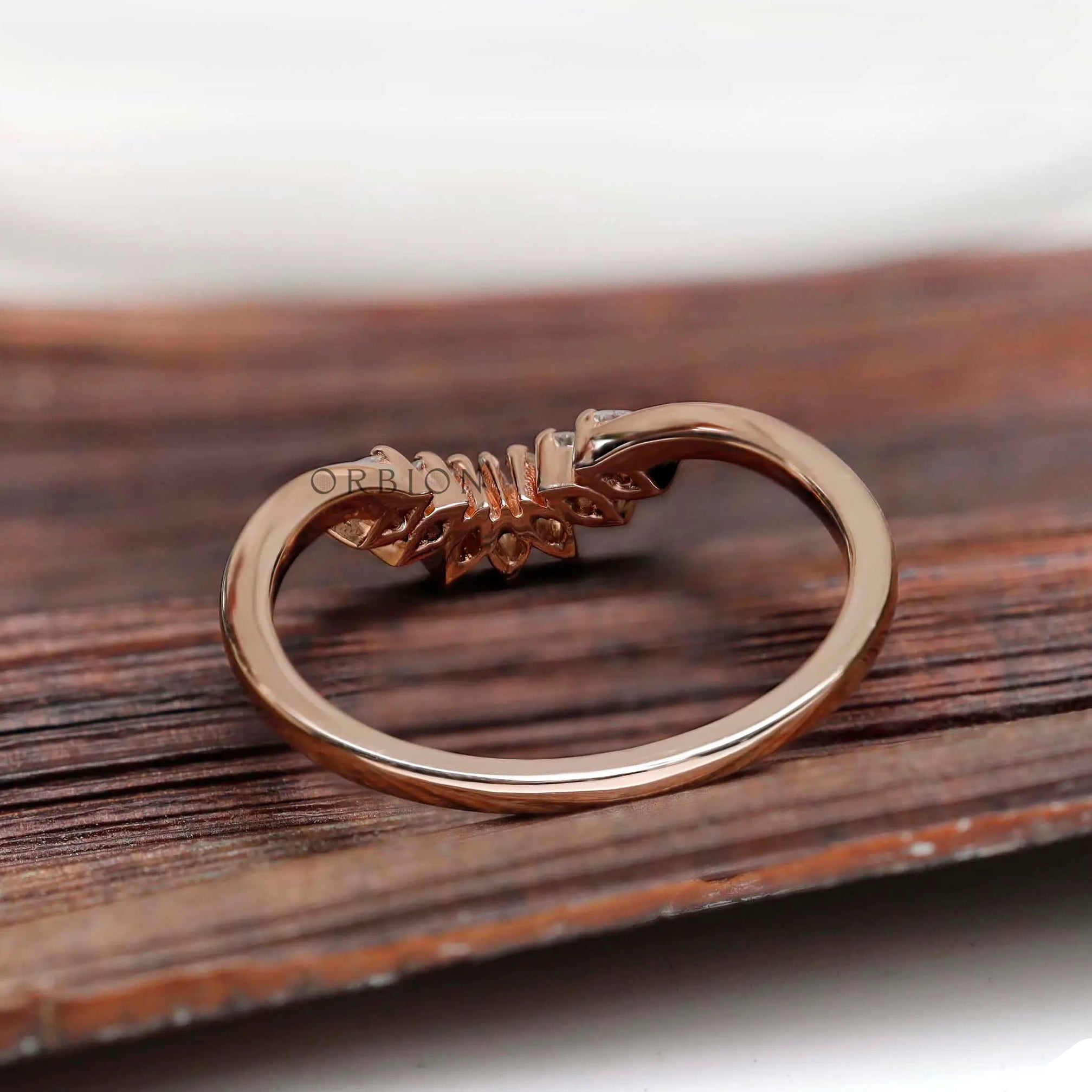 Back view of rose gold curved nesting band with marquise moissanite setting